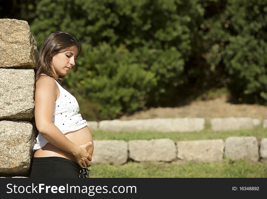 Beautiful pregnant woman relaxing in the park