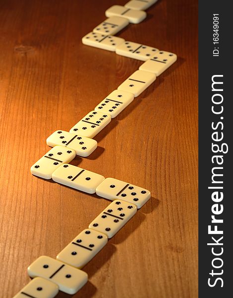 Long line made from dominoes on wooden background. Long line made from dominoes on wooden background
