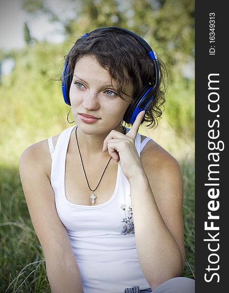 Young girl listens to music on the nature