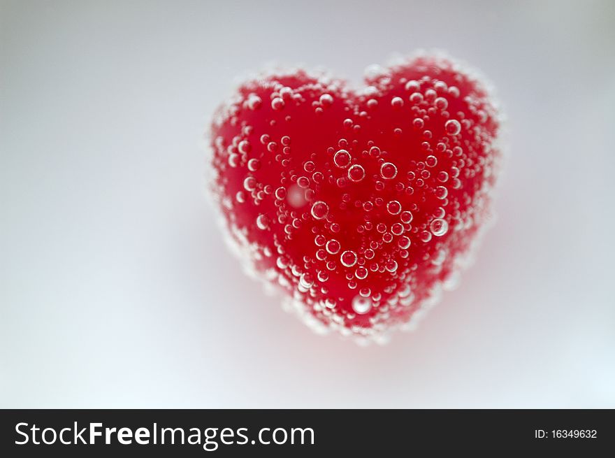 Candy heart with bubbles under water.