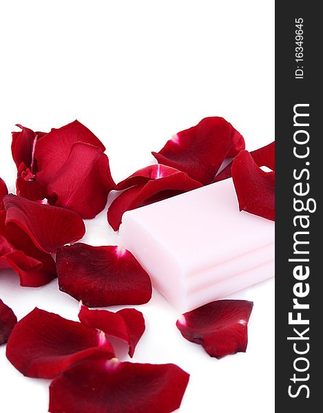 Pink soap with rose petals on white