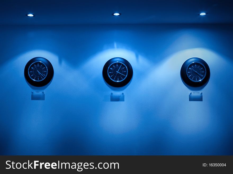 Row of clock on the wall illuminated by lamps, Monochromatic. Row of clock on the wall illuminated by lamps, Monochromatic