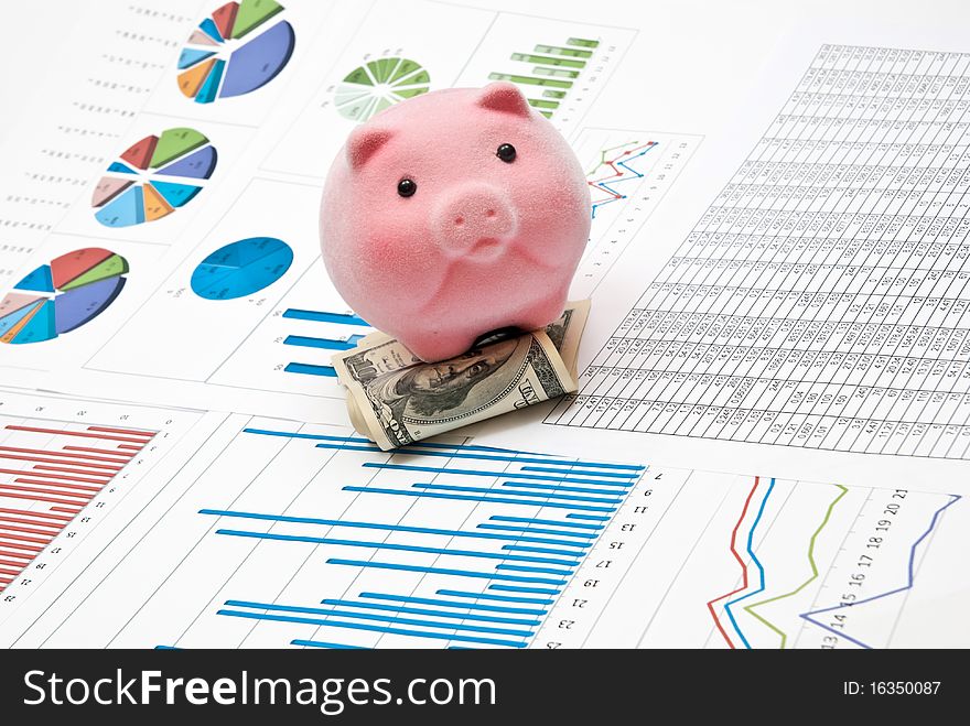 Piggy bank on money with business charts. Piggy bank on money with business charts