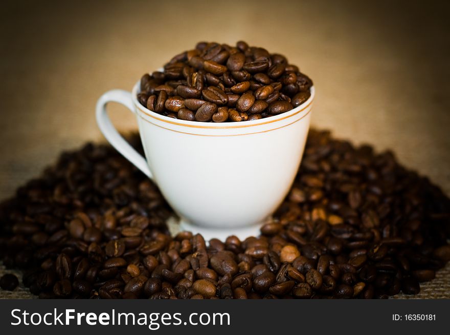 The cup full of the fresh and grain coffee. The cup full of the fresh and grain coffee.