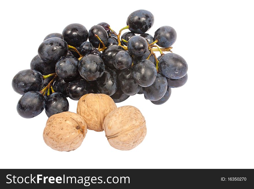 A bunch of grapes and three walnuts isolated on white background. A bunch of grapes and three walnuts isolated on white background