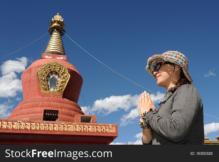 Portrait of a Buddhist pilgrim with hands together for prayer in front a famous stupa. Portrait of a Buddhist pilgrim with hands together for prayer in front a famous stupa.