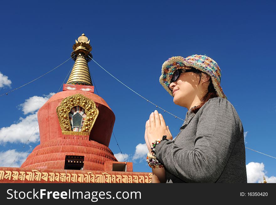 Portrait of a Buddhist pilgrim with hands together for prayer in front a famous stupa. Portrait of a Buddhist pilgrim with hands together for prayer in front a famous stupa.