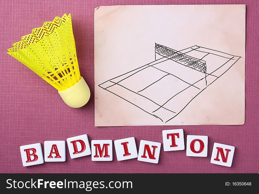 A yellow synthetic badminton shuttlecock next to a drawing of a badminton court.