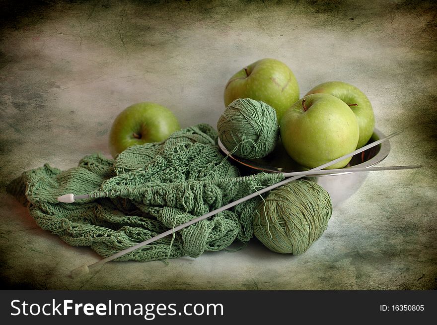 Still life consists of green apples and green balls of threads. Still life consists of green apples and green balls of threads