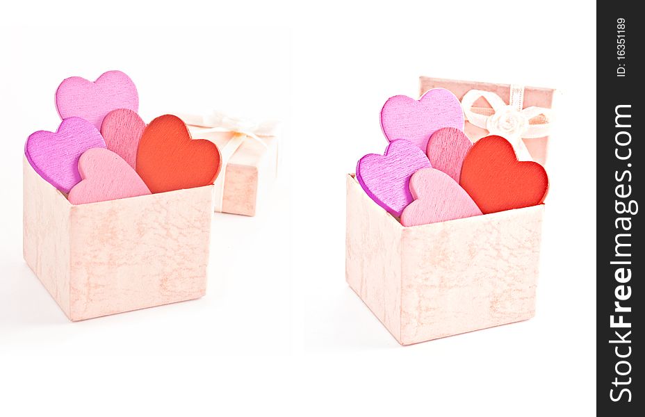 Wooden heart-shaped pink color Gift Box on the white background. Macro photo.