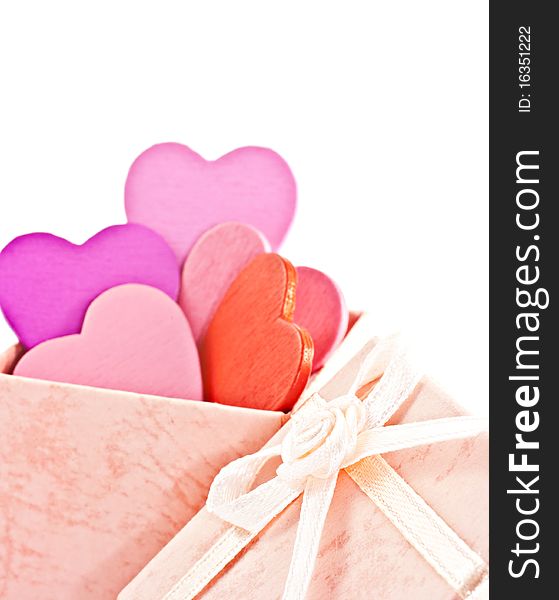 Wooden heart-shaped pink color Gift Box on the white background. Macro photo.