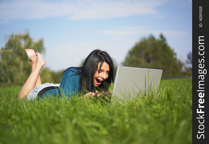 Young woman using laptop in park. Young woman using laptop in park