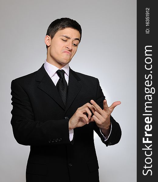 Young handsome business man in a formal suit counting on fingers. studio shot