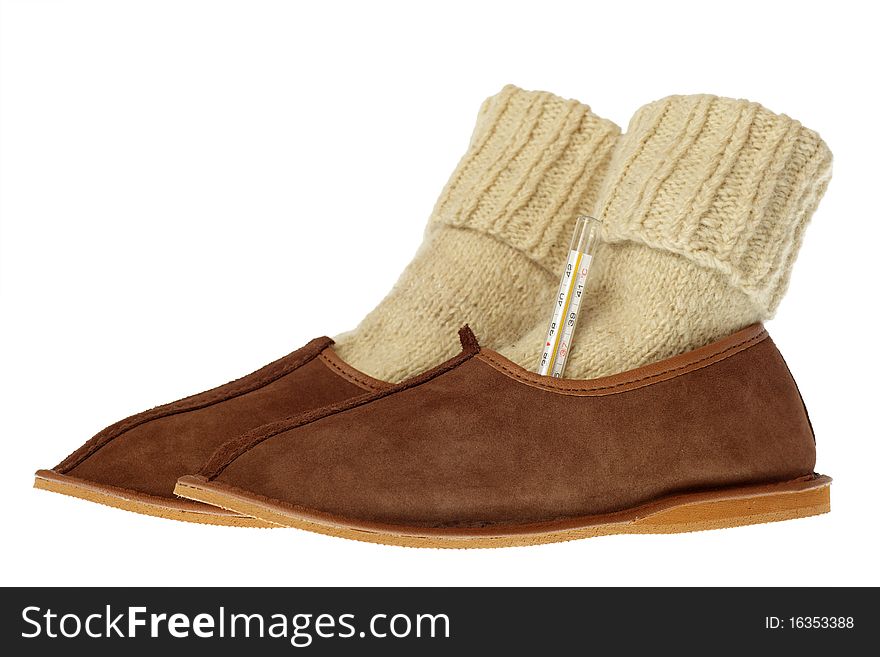 Isolated brown wool comfortable slippers and thermometer. Isolated brown wool comfortable slippers and thermometer