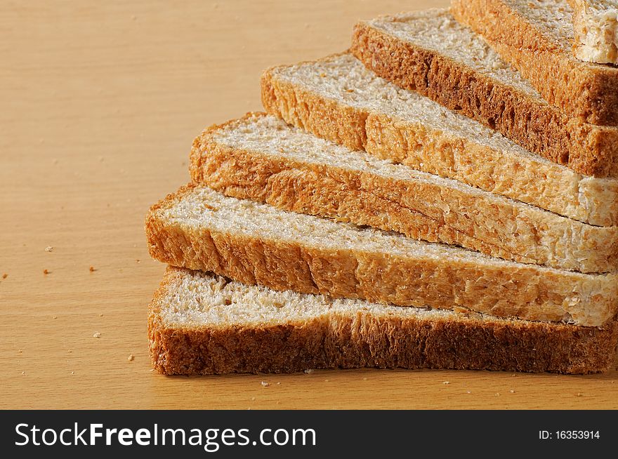 Pile up wheat bread that looks like a stair on the wooden table. Pile up wheat bread that looks like a stair on the wooden table