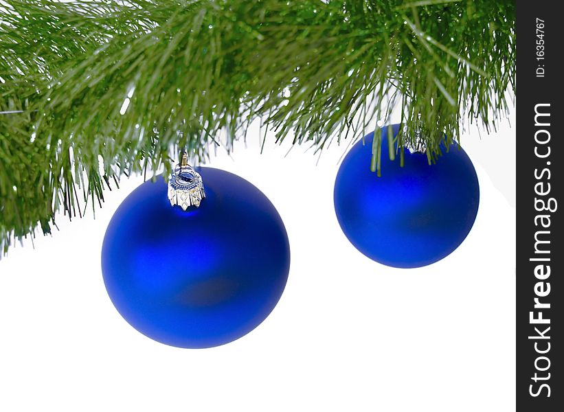 Two blue christmas ball hanging on w green christmas tree branch, against a wjite background. Two blue christmas ball hanging on w green christmas tree branch, against a wjite background