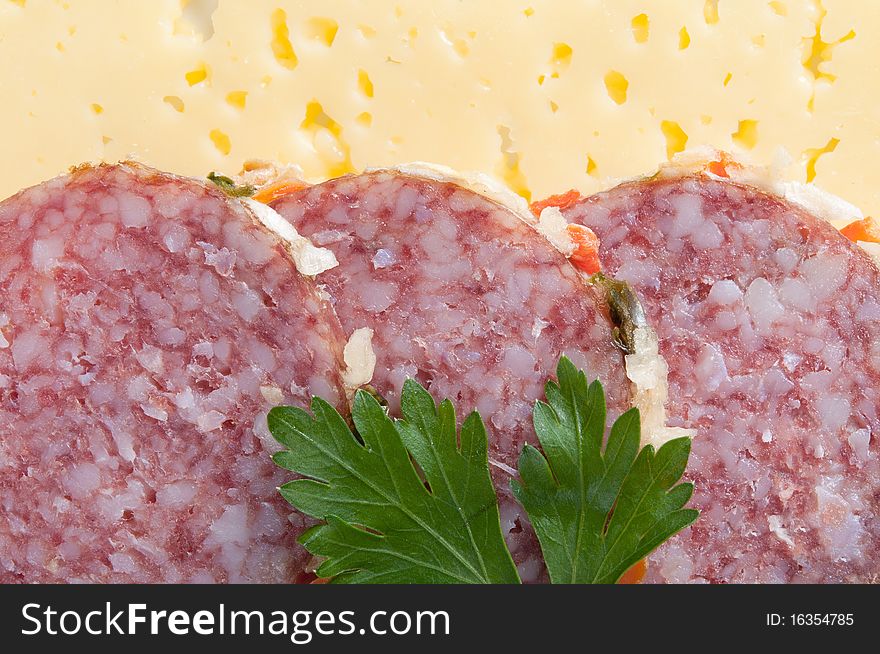 Close up of sliced salami with parsley on cheesy background. Close up of sliced salami with parsley on cheesy background