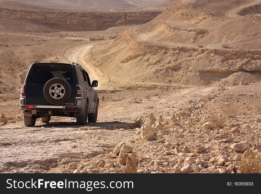 This is an image of a SUV vehicle in the Negev desert in Israel. This is an image of a SUV vehicle in the Negev desert in Israel