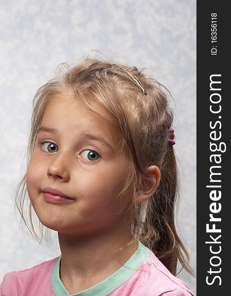 Little smiling girl portrait isolated over light blue background