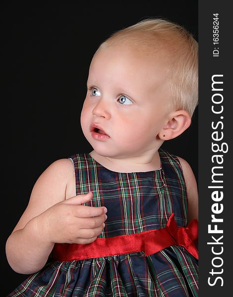 Beautiful blond toddler wearing a christmas dress