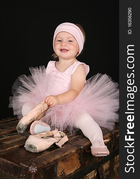 Blond toddler wearing a tutu holding pointe shoes. Blond toddler wearing a tutu holding pointe shoes