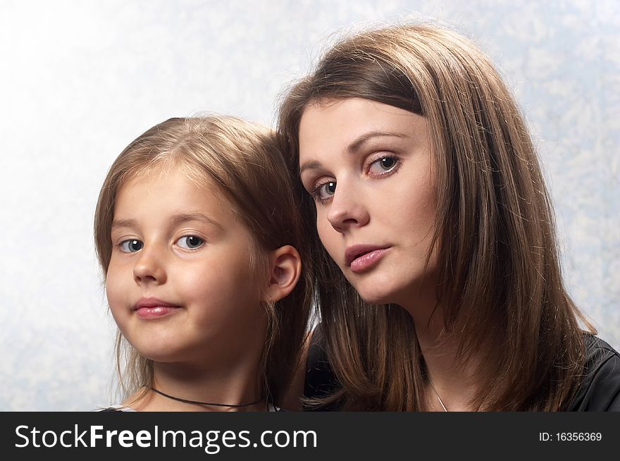 Mother and daughter portrait over light defocused background