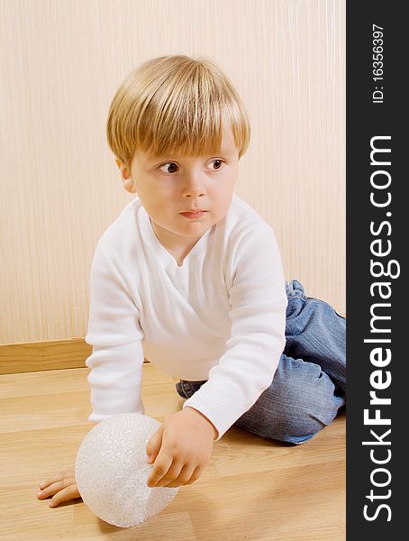 The child on the wood floor with white ball. The child on the wood floor with white ball