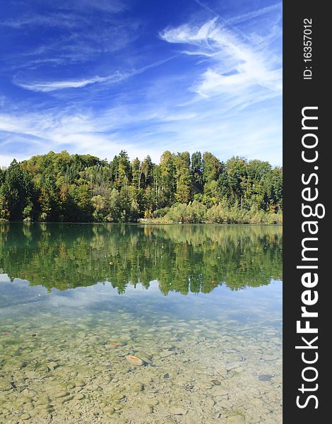 Green lake with colorful wood and blue sky in autumn. Green lake with colorful wood and blue sky in autumn