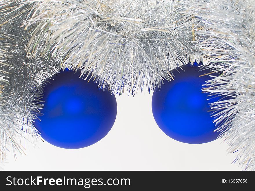 Two blue christmas ball hanging over silver christmas chain, against a white background. Two blue christmas ball hanging over silver christmas chain, against a white background