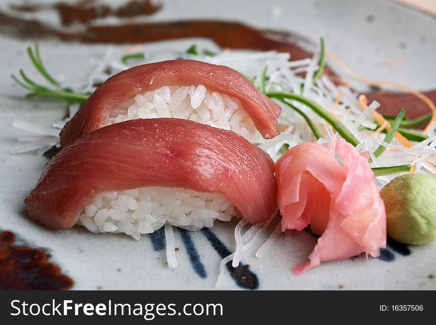 Japanese sushi served with rice, sliced ginger and wasabi.