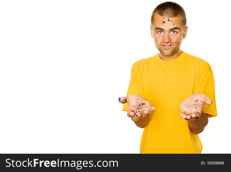 Handsome young man, his face and hands stained the ground. The guy pulls his hands to frame complaining. Isolated on a white background. Handsome young man, his face and hands stained the ground. The guy pulls his hands to frame complaining. Isolated on a white background