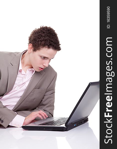 Young man typing and looking at screen of laptop, isolated on white, studio shot