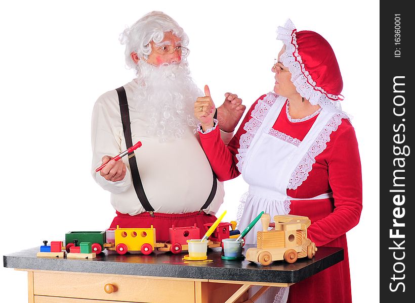 Mrs. Claus giving Santa a thumbs-up for the paint-job on the wooden train he's been working on for Christmas giving.  Isolated on white. Mrs. Claus giving Santa a thumbs-up for the paint-job on the wooden train he's been working on for Christmas giving.  Isolated on white.