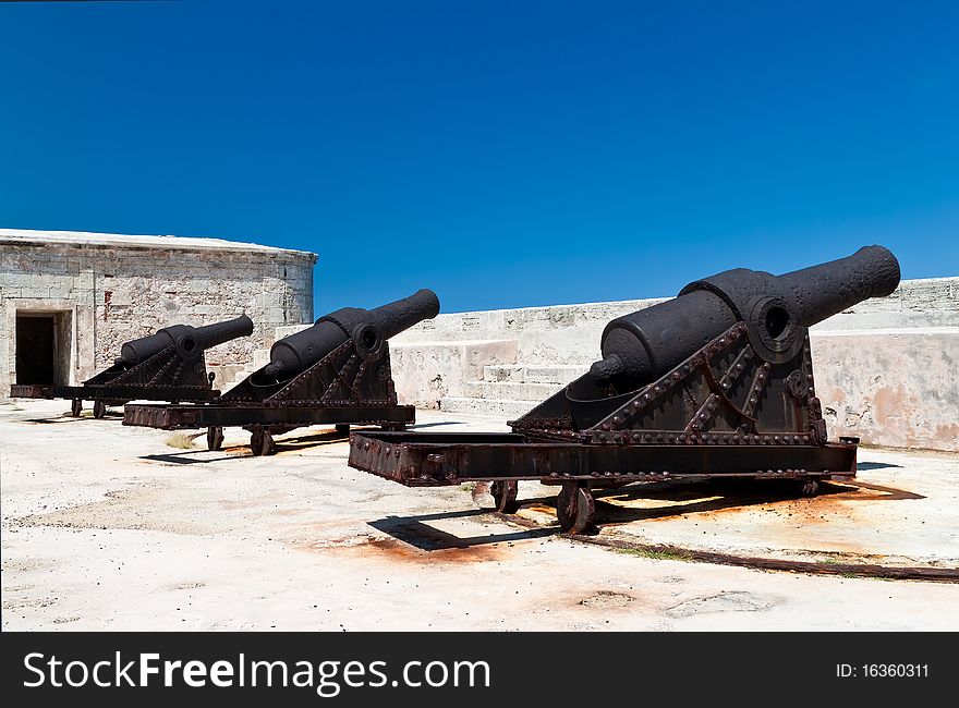 Group of ancient cannons in a stone castle on a day with a clear blue sky. Group of ancient cannons in a stone castle on a day with a clear blue sky