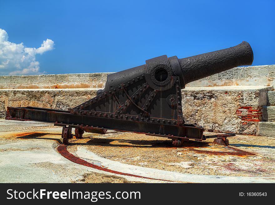 Old rusty cannon on a castle with a clear blue sky