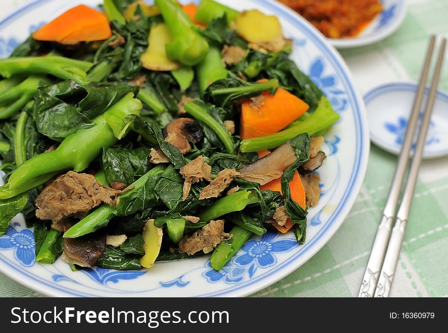 Asian style mixed vegetable delicacy cooked with leafy vegetables, mushrooms, carrots, and slices of ginger.