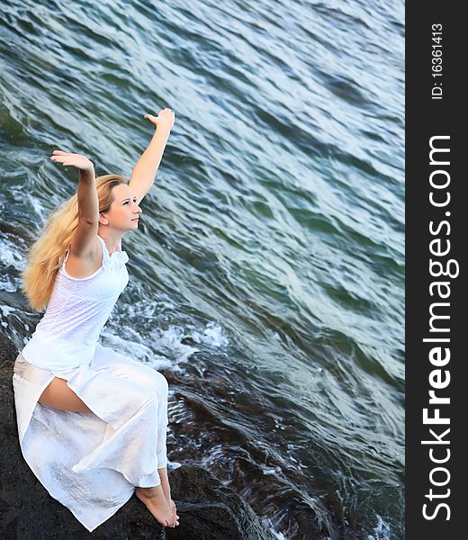 Young beautiful woman posing near the ocean. Young beautiful woman posing near the ocean