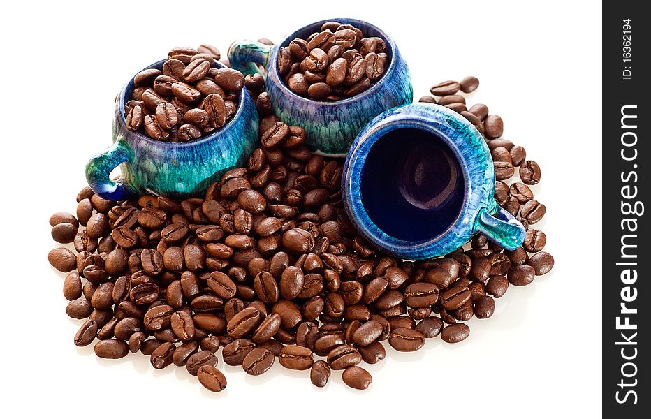 Fresh coffee beans and colorful cups on a white background. Fresh coffee beans and colorful cups on a white background