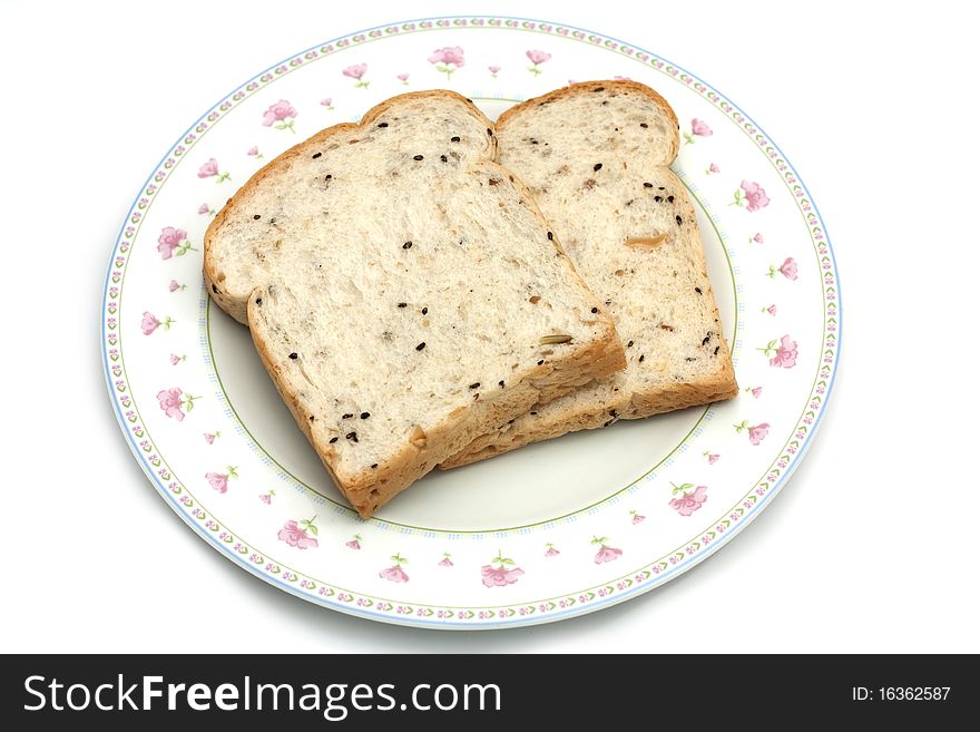 The healthy food, whole wheat for breakfast. Two piece of bread on white disk isolated on white background. The healthy food, whole wheat for breakfast. Two piece of bread on white disk isolated on white background.