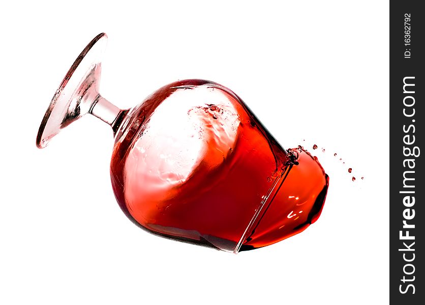 Red wine spilling from a transparent glass isolated on a white background