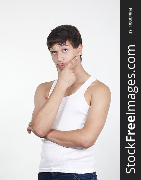 Closeup of a handsome young teenaged guy looking away in thought isolated on white