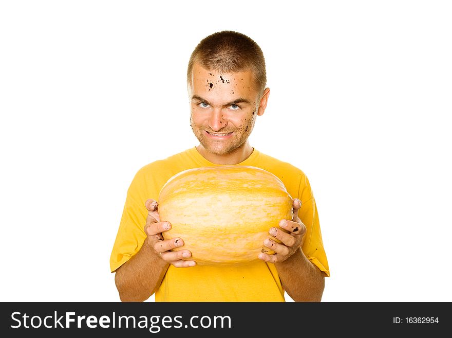 Handsome young man holding a big yellow pumpkins in their hands. An evil smile. Lots of copyspace and room for text on this isolate. Handsome young man holding a big yellow pumpkins in their hands. An evil smile. Lots of copyspace and room for text on this isolate