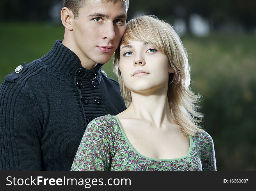 Casual beautiful young couple relaxing and cuddling in the park. Casual beautiful young couple relaxing and cuddling in the park