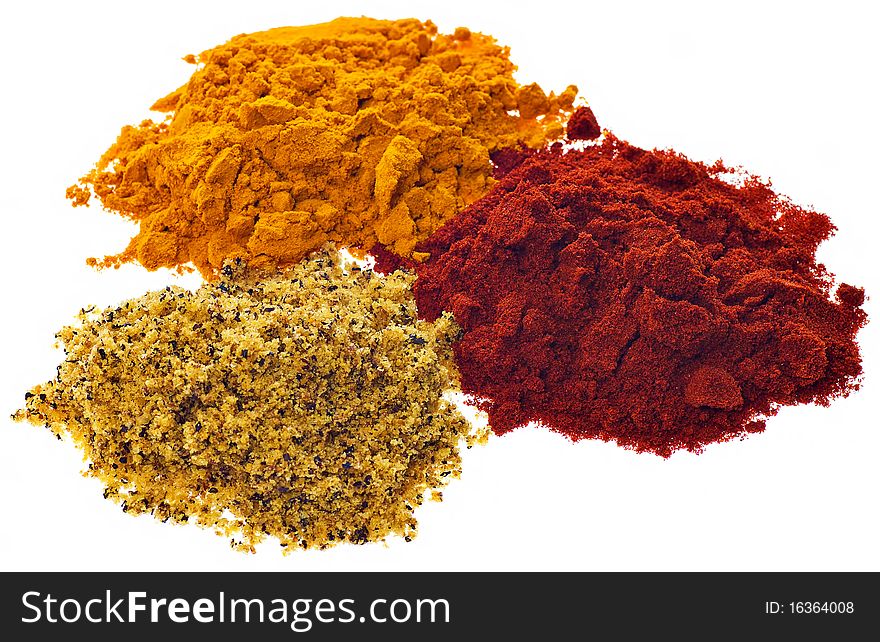 Three different brightly colored powdered spices on a white background. Three different brightly colored powdered spices on a white background