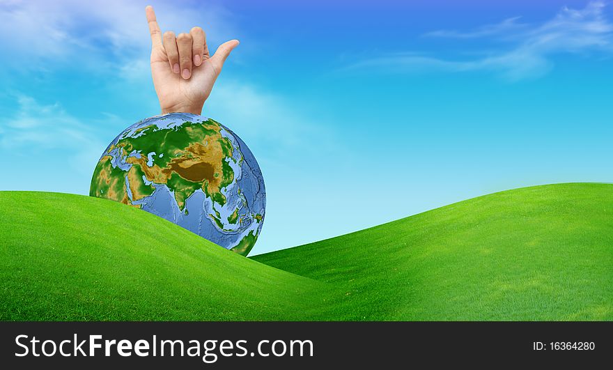 A hand with a globe and a grass field