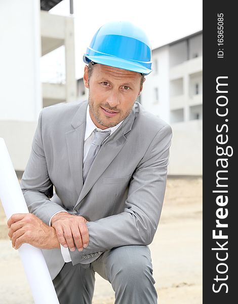 Businessman with helmet checking site under construction. Businessman with helmet checking site under construction