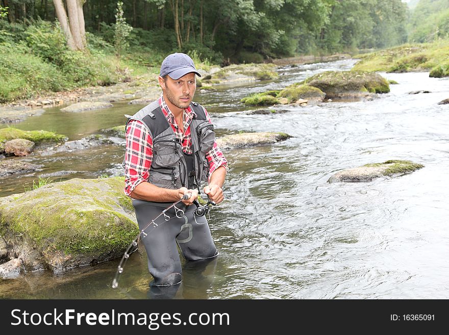 Fisherman in river with fishing rod. Fisherman in river with fishing rod