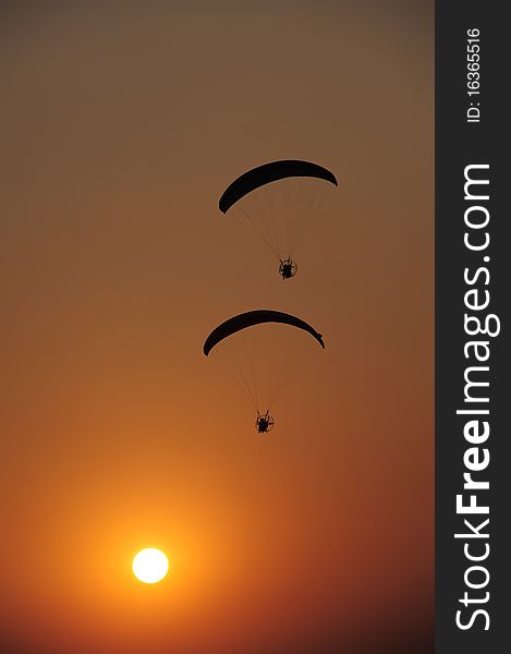 Two Paramotors flying at sunset. Two Paramotors flying at sunset