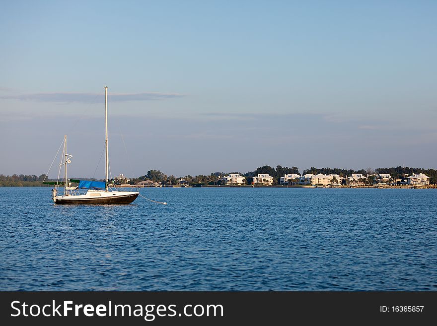 Sailboat on the water with home in the background