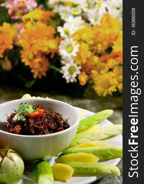 A tom yum sauce of shrimp paste and chili cuisine and vegetables with flower background